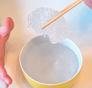 Softened thermoplastic on a stick over a bowl