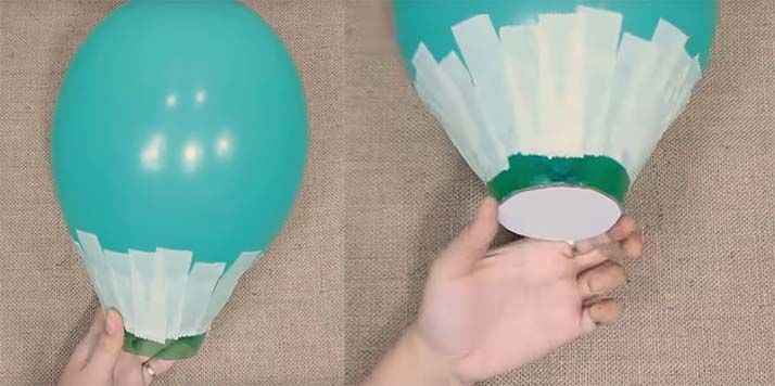 Нижнюю часть бутылки фиксируют малярной лентой на воздушном шаре