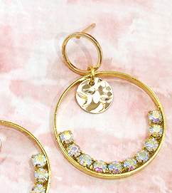 Close-up of a hoop earring with rhinestones and a round charm
