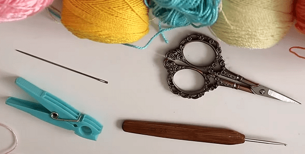Supplies for crocheting bows: yarn, hook, needle, and clothespin