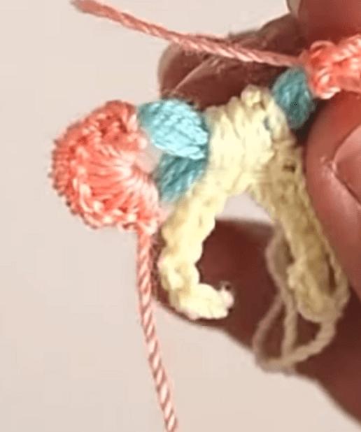 Multicolored crocheted bow during assembly