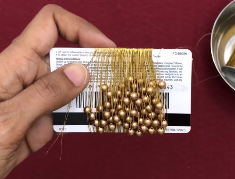 Golden beaded thread wound around a card