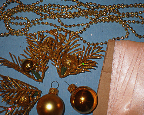 Gold holiday sprig with ornaments and ribbon for decoration