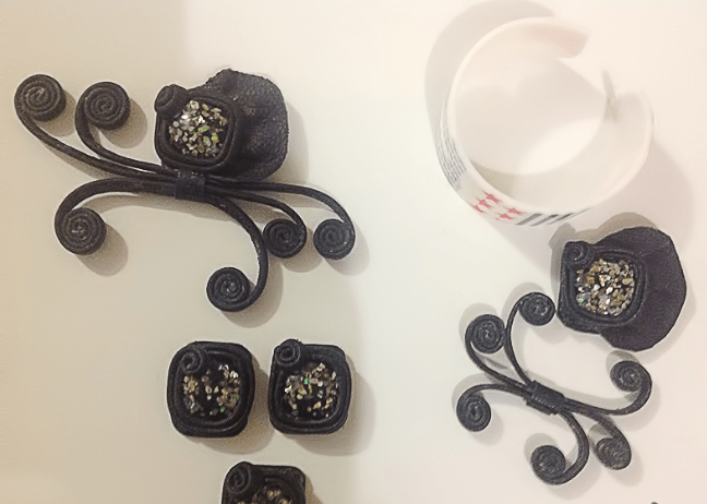 Leather jewelry-set pieces arranged beside trim