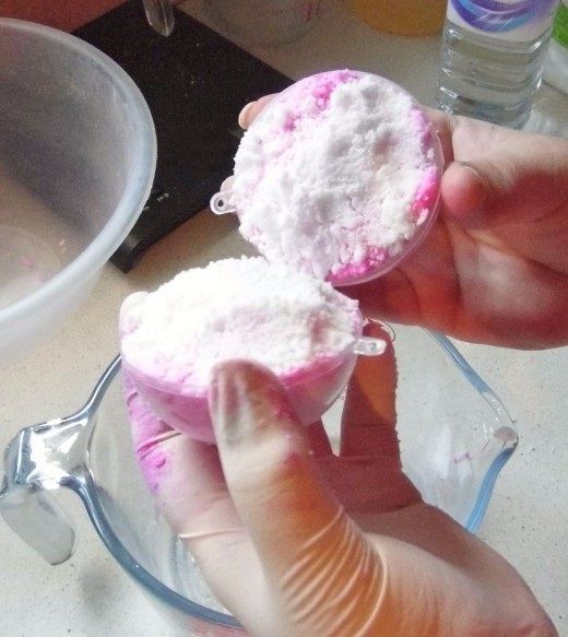 Две половинки формы с смесью для бомбочки для ванны в руках