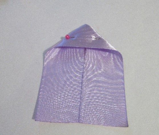 Folded lilac ribbon secured with a pin