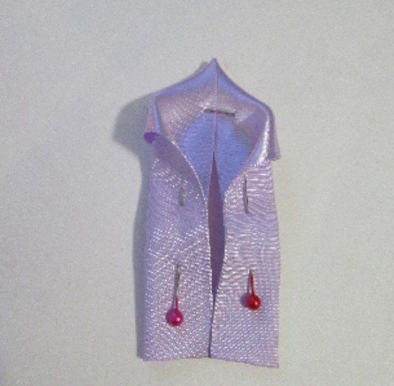 Folded lilac ribbon with tucked edges pinned in place