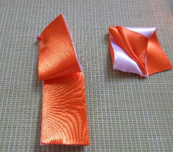 Folded edge of two-tone ribbon to form a petal