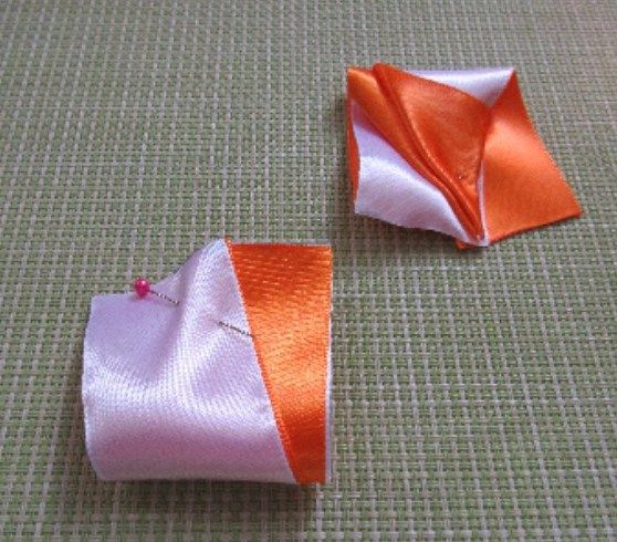Folded petal piece secured with a pin