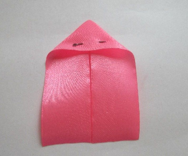 Folded satin ribbon for a bow, secured with a pin