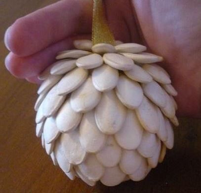 Finished pumpkin seed pinecone on a gold ribbon
