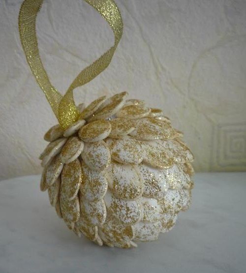 Holiday pinecone from pumpkin seeds with a gold ribbon