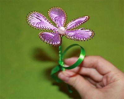Ganutell flower with lilac petals and a bead in the center