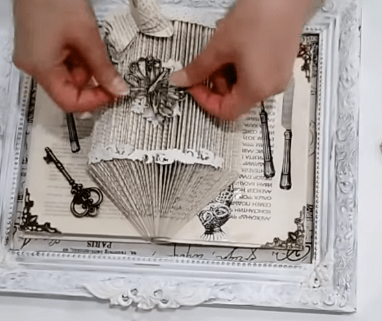 The finished 3D book art piece in a frame