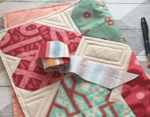 Patchwork project and a strip of binding tape before binding the edge
