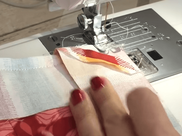 Stitching across the corner of the project with tape binding