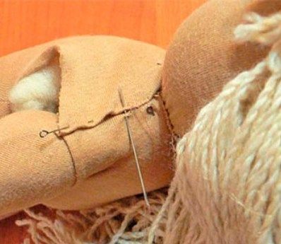 Gathering the shoulder section of a Waldorf doll with threads