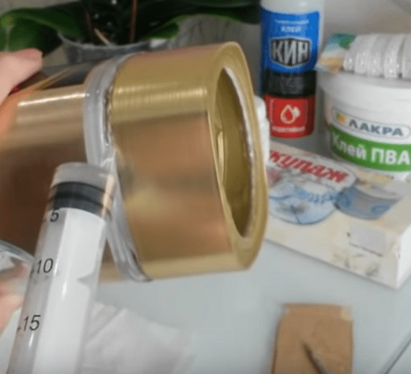 Glue being injected with a syringe into the groove beneath the jar lid