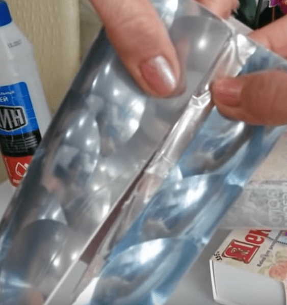 Foamiran sheet with a raised design being glued onto a jar with overlapping edges