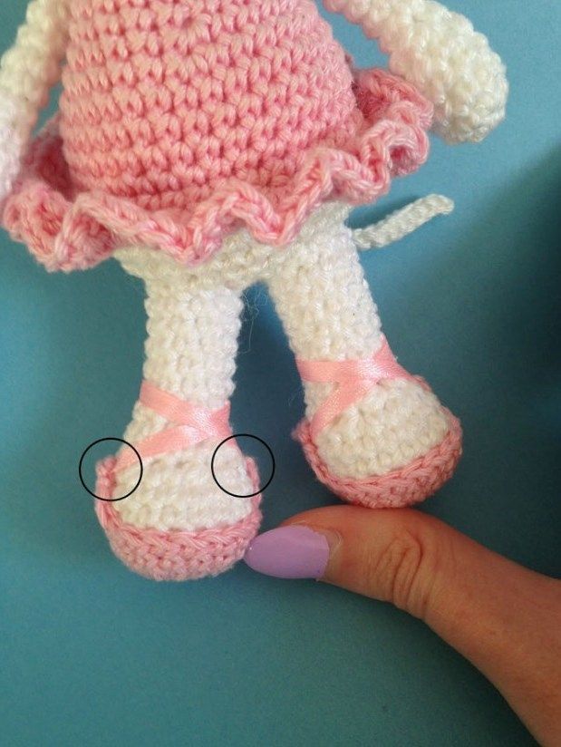 Legs of a crochet mouse in pink shoes