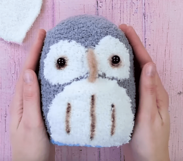Gray side of the sock plush toy with a white face and belly
