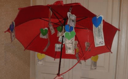 An open umbrella decorated with hanging money and ornaments