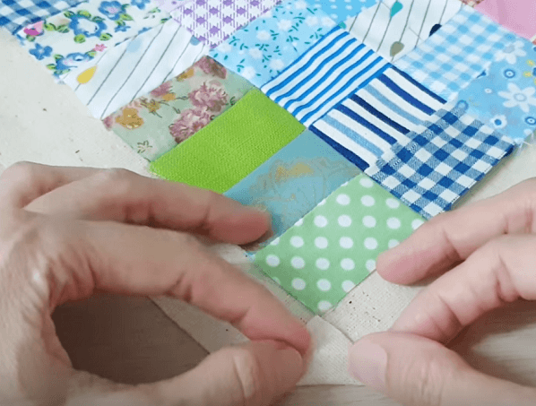 Folding the backing's corner toward the edge of the patchwork napkin