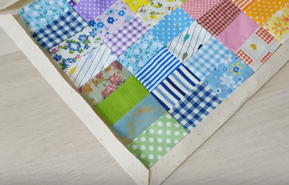 The backing's edge folded around the patchwork napkin
