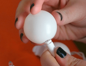 Inserting a light bulb into the ping pong ball
